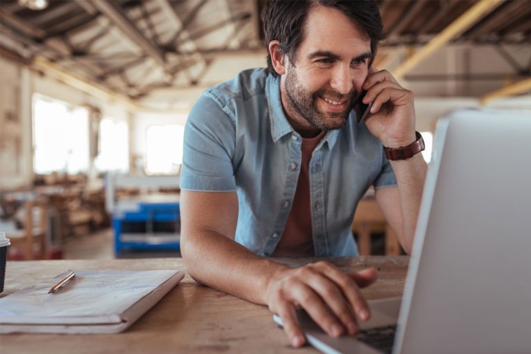 Mann med laptop på et verksted