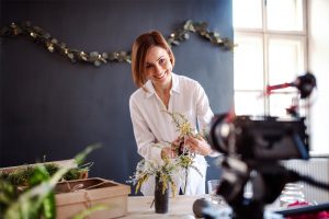 Kvinne som setter opp blomster og tar bilder